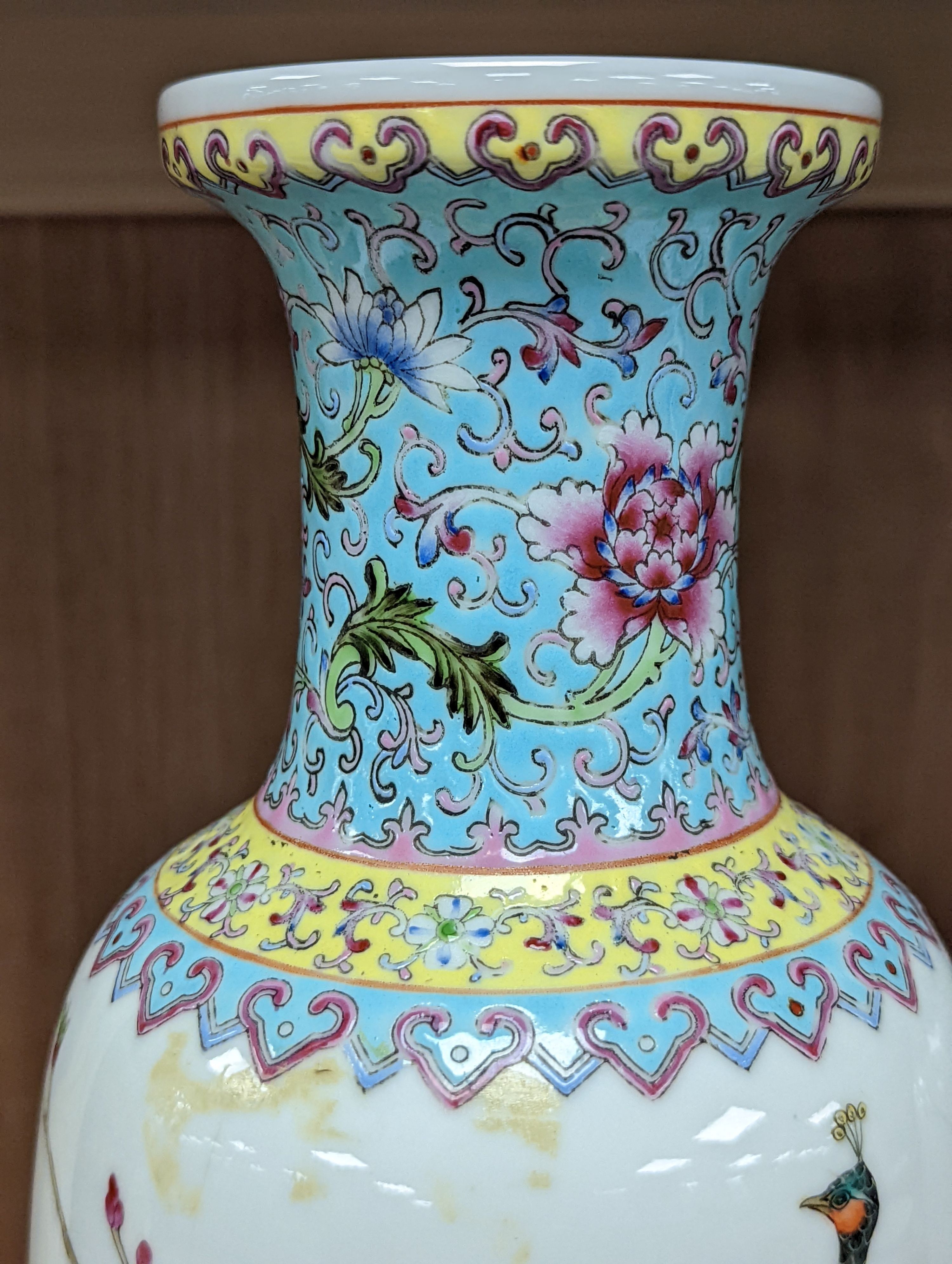 A pair of Chinese famille rose vases decorated with peacocks, 31cm